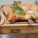 Grilled salmon with fresh herb garnish served on a John Boos cutting board