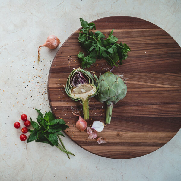 round butting board with vegetables on top