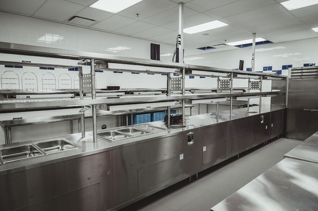 interior of commercial kitchen with stainless steel equipment