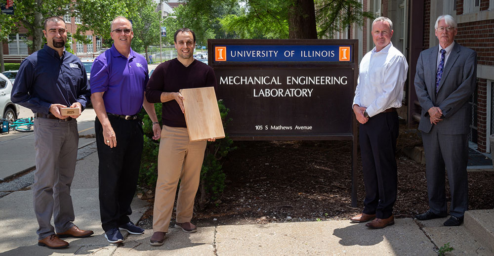 businessmen standing in front of University of Illinois Mechanical Engineering Lab sign