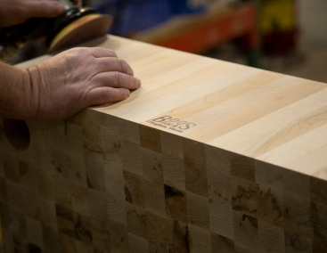 craftsmen sanding a wood cutting board