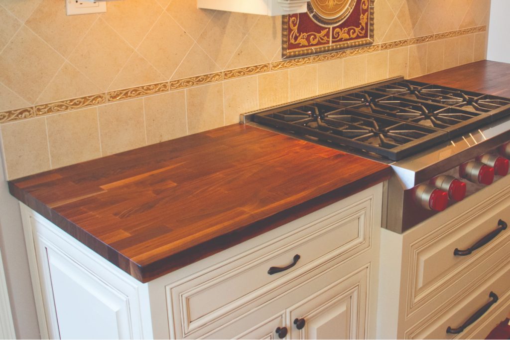 natural wood countertops with white cabinets and gas range oven